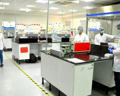 Laboratory staff working at a bench, from the official DTI website